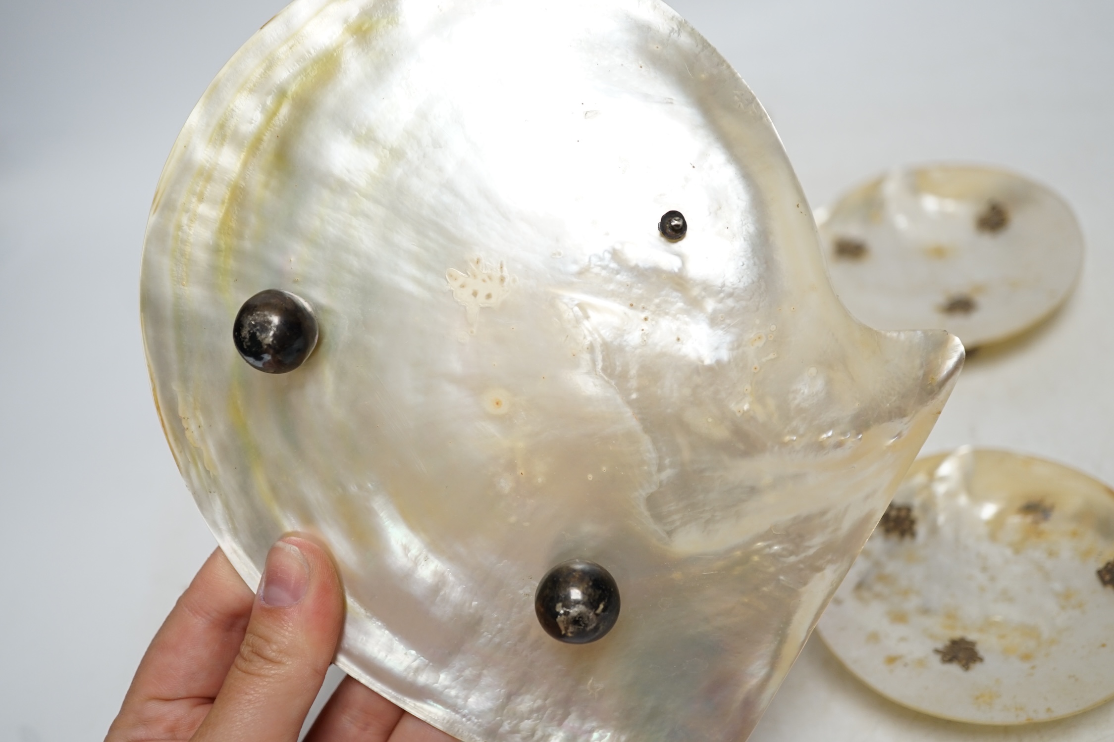 Six Chinese mother-of-pearl dishes on metal ball feet, largest 17.5cm wide. Condition - two ball feet missing on both larger shell dishes